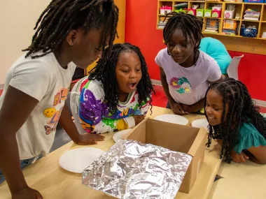 young girls taking part in an MRC STEM activity at a partner school summer camp