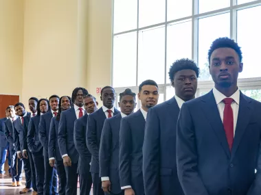 Young Men United graduates posing for a photo in their suits at the ceremony